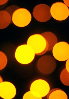 Gold-gelbe Punkte auf schwarzem Hintergrund, leicht verschwommen, wie Lichter, die in der nacht funkeln